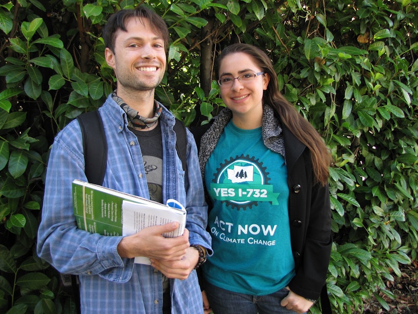 caption: Ben Silesky, 26, and Sydney Allen, 21, go door to door to raise awareness and support for ballot Initiative 732, which would put a tax on carbon emissions in Washington.