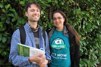 caption: Ben Silesky, 26, and Sydney Allen, 21, go door to door to raise awareness and support for ballot Initiative 732, which would put a tax on carbon emissions in Washington. 
