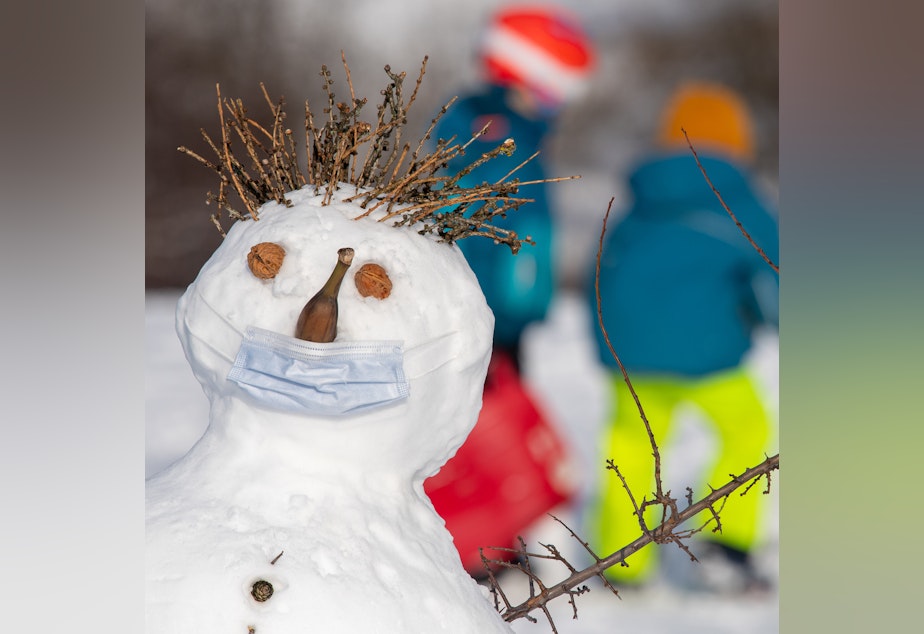 caption: 07 January 2021, Bavaria, Munich: The snowman "Claude", who was built on a hill in the Olympic complex, wears a mouth-nose protection over his nose, which is made of a banana.