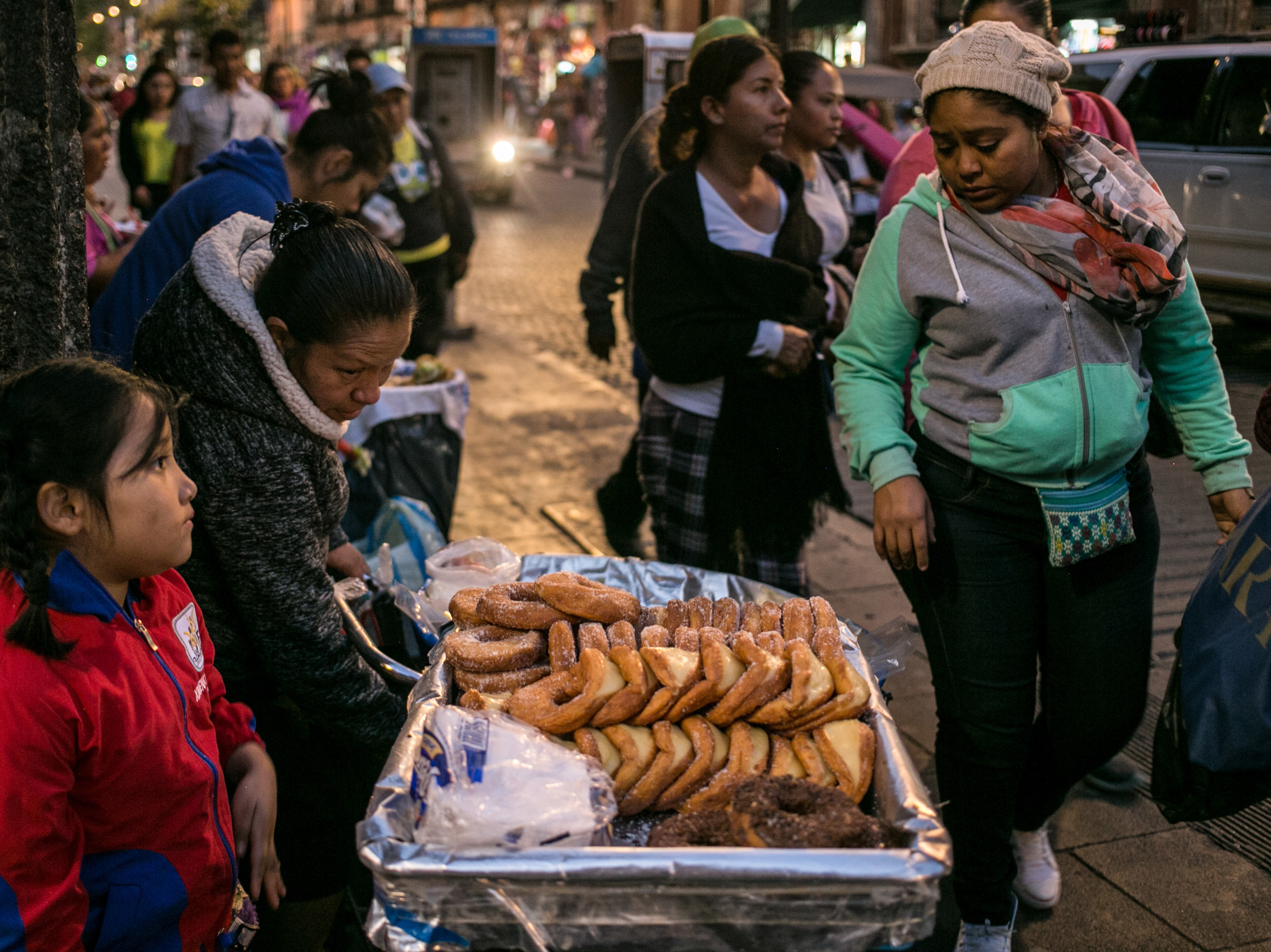 caption: A family sells pastries in Mexico City. As Mexicans' wages have risen, their average daily intake of calories has soared.