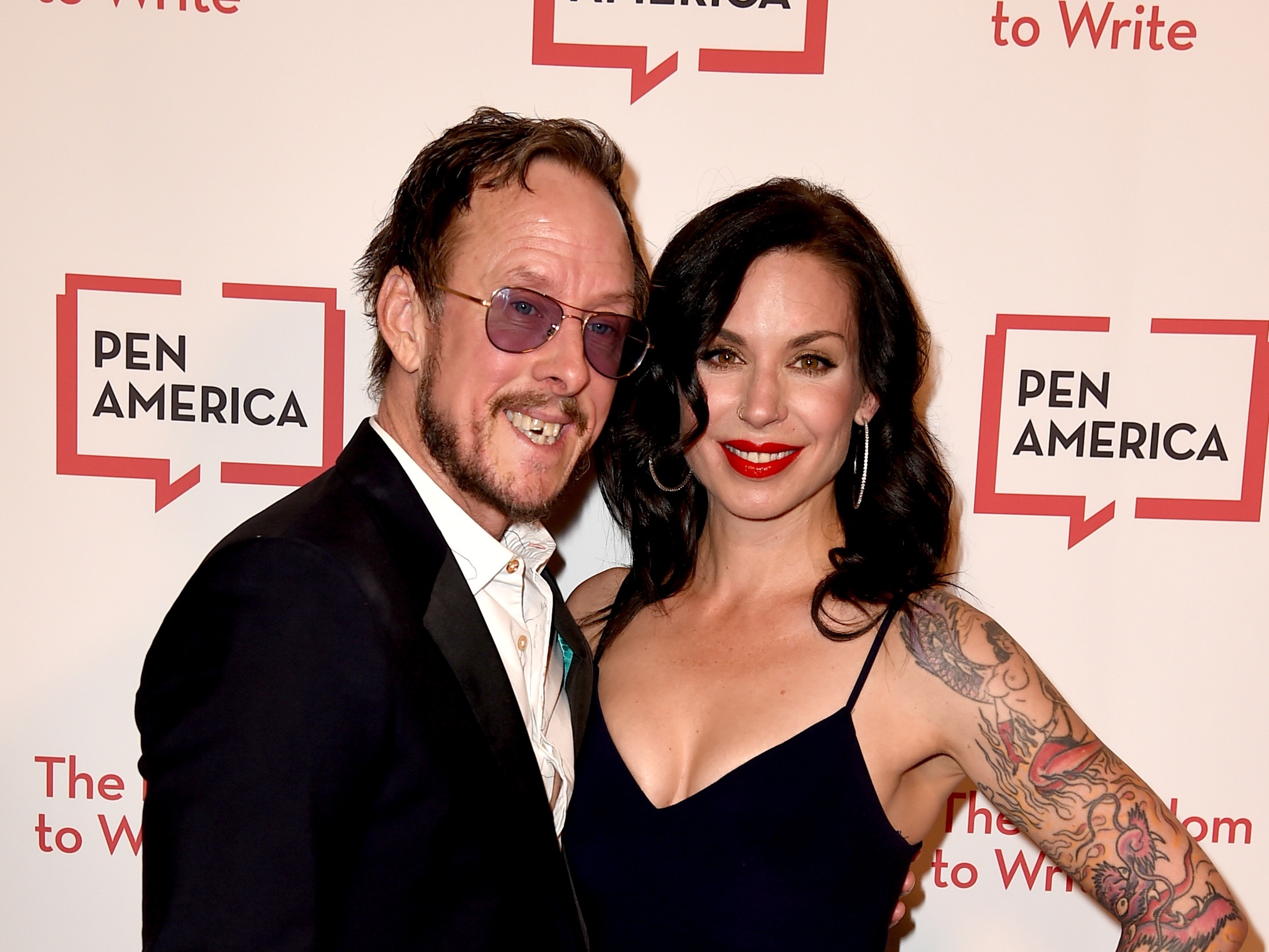 caption: When police came to the cul de sac road in Los Angeles where Jillian Lauren lives with her husband, Weezer bassist Scott Shriner, they were pursuing a suspect in a hit-and-run. But Lauren was shot after police say she pointed a gun at them. The couple are seen here in 2018.