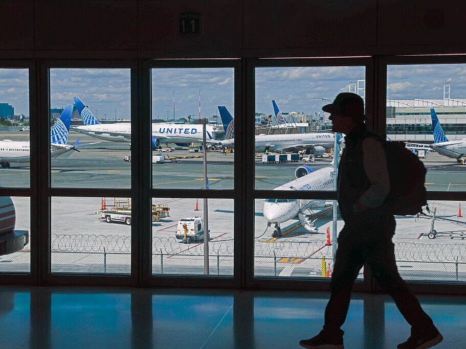 caption: A traveler walks through Newark Liberty International Airport in early June. United Airlines says Newark was the most reliable airport in the New York City area in June — a remarkable turnaround after a wave of cancellations and delays in April and May.