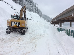 caption: That road was covered by 15 feet of snow in the Snoqualmie Pass area. (The road is still six feet under the excavator.) More than 112 inches of snow have fallen in the last seven days.