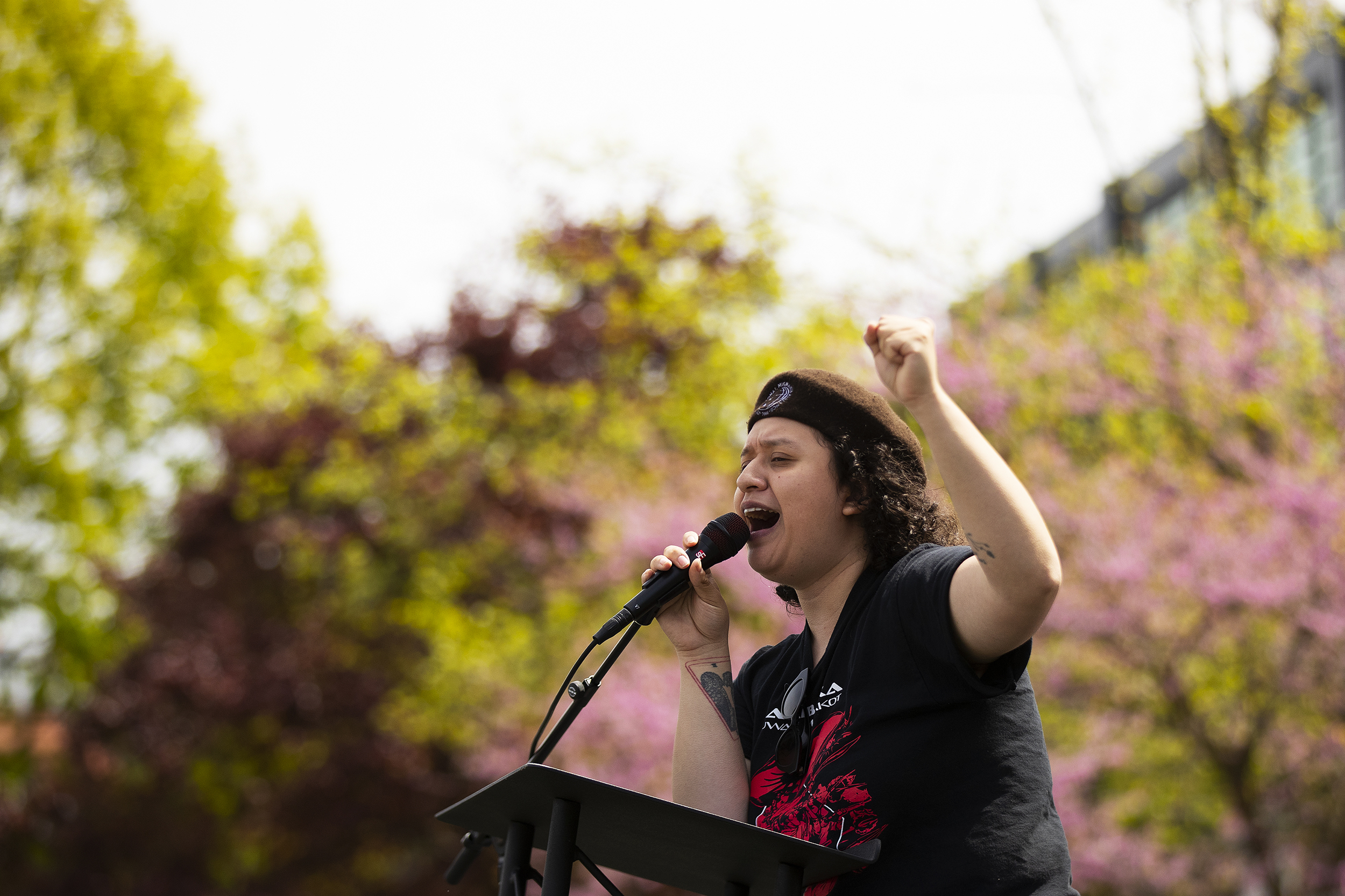 caption: Inez, an MC with the International Migrants Alliance, speaks during the annual May Day rally on Friday, May 1, 2026, at Cal Anderson Park in Seattle. 