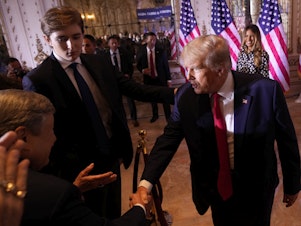 caption: Former President Donald Trump greets people after announcing he is running for president for the third time as he speaks at Mar-a-Lago in Palm Beach, Fla., in 2022 as his son, Barron Trump, watches.