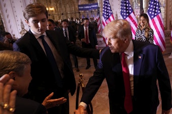 caption: Former President Donald Trump greets people after announcing he is running for president for the third time as he speaks at Mar-a-Lago in Palm Beach, Fla., in 2022 as his son, Barron Trump, watches.