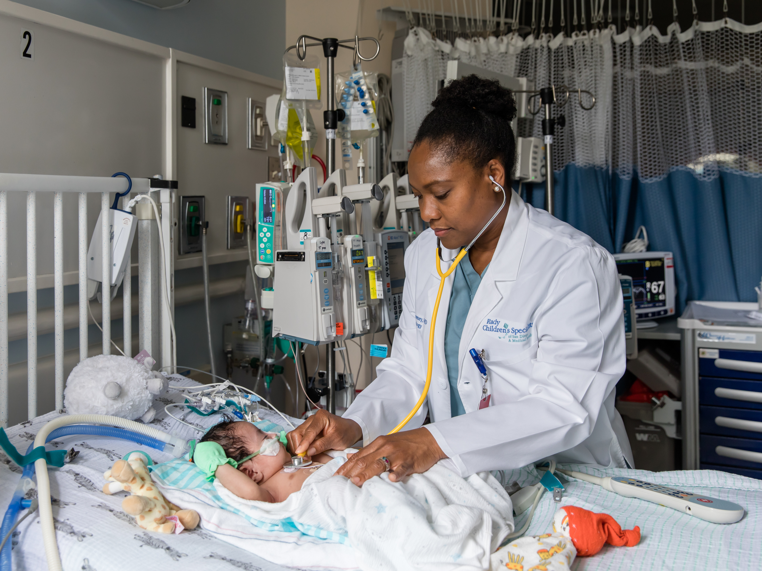 caption: Nathaly Sweeney, a neonatologist at Rady Children's Hospital-San Diego and researcher with Rady Children's Institute for Genomic Medicine, attends to a young patient in the hospital's neonatal intensive care unit.