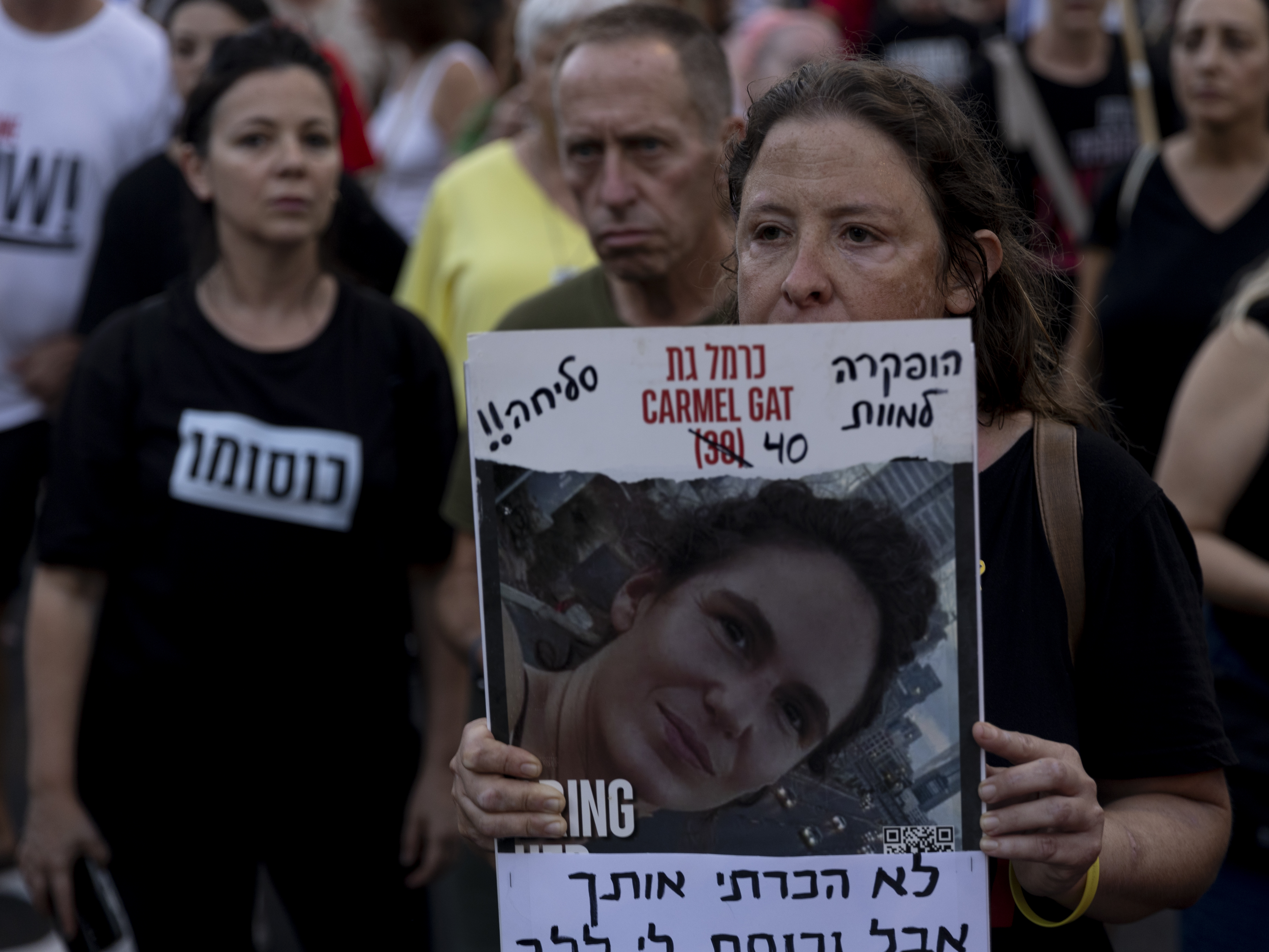 caption: A protester holds a photo of slain hostage Carmel Gat, killed in captivity in Gaza during a rally calling for an immediate hostage deal and release of hostages held by Hamas in the Gaza Strip on September 2, 2024 in Tel Aviv, Israel.
