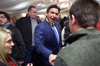 caption: Republican presidential candidate and Florida Gov. Ron DeSantis greets guests after speaking during the Scott County Fireside Chat at the Tanglewood Hills Pavilion in Bettendorf, Iowa.