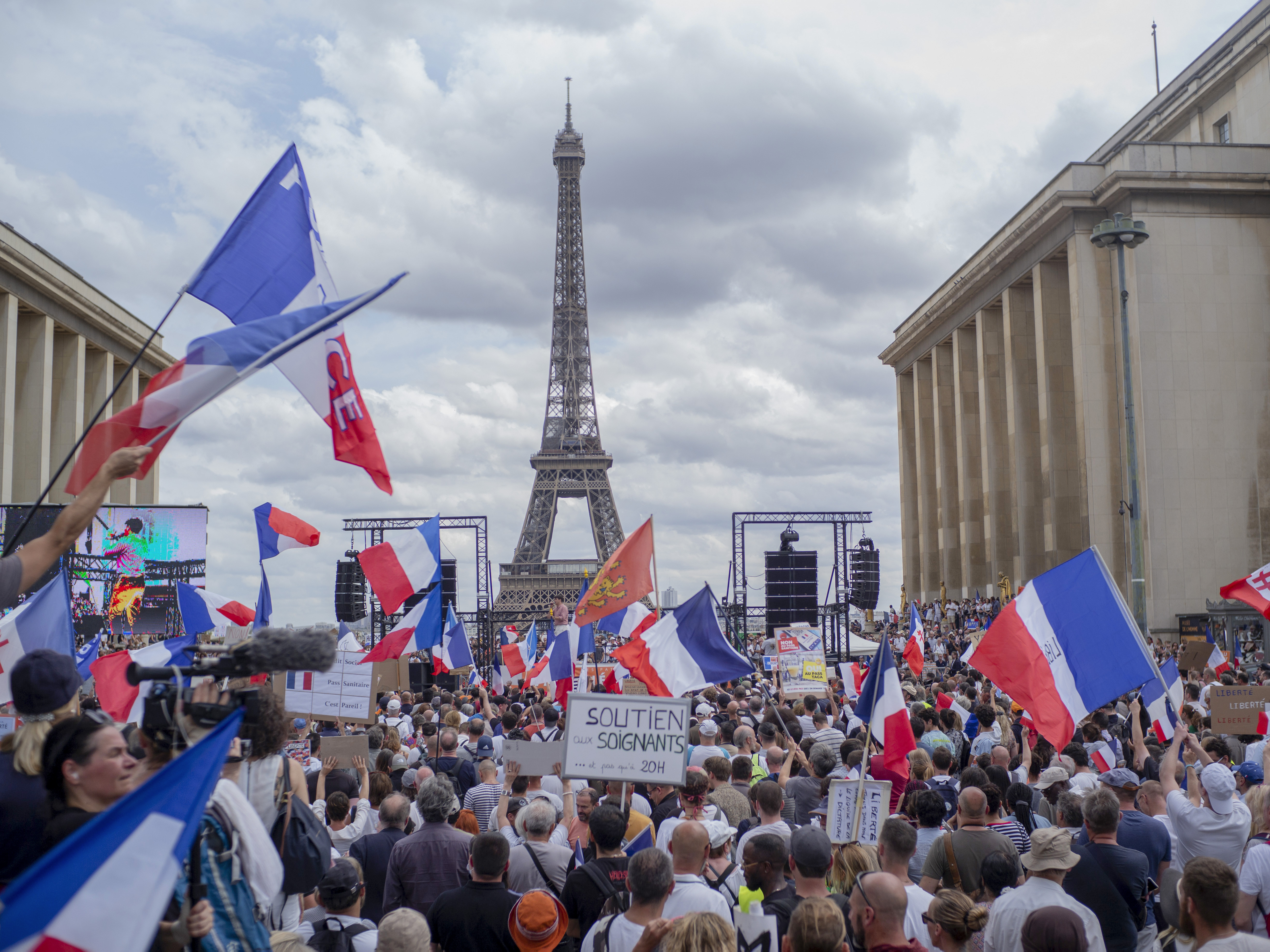 caption: Thousands of protesters gather near the Eiffel Tower to protest the COVID-19 pass which grants vaccinated individuals greater ease of access to venues.