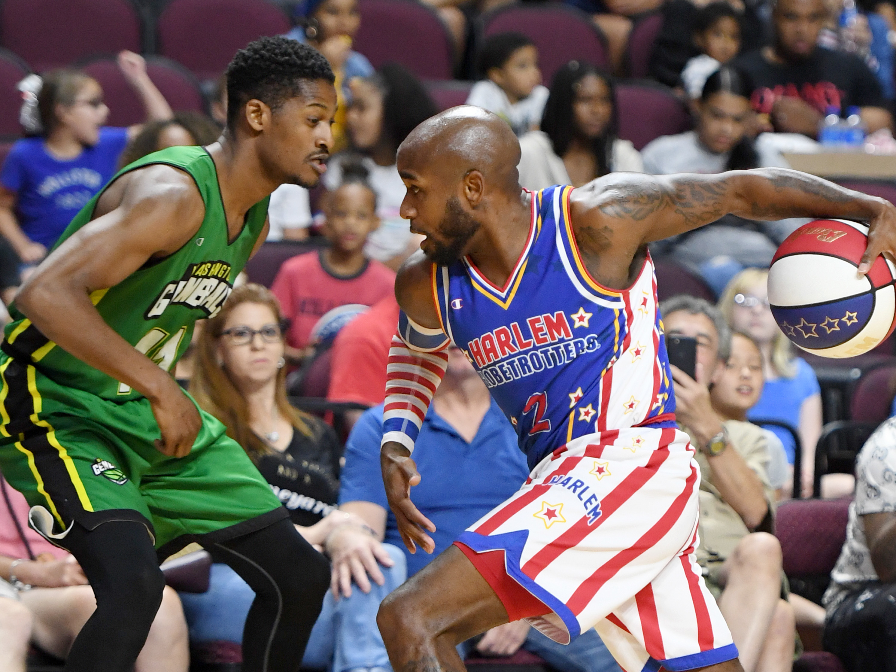 caption: Carlos "Dizzy" English of the Harlem Globetrotters drives against Shaquille Burrell of the Washington Generals during their exhibition game at the Orleans Arena near Las Vegas.