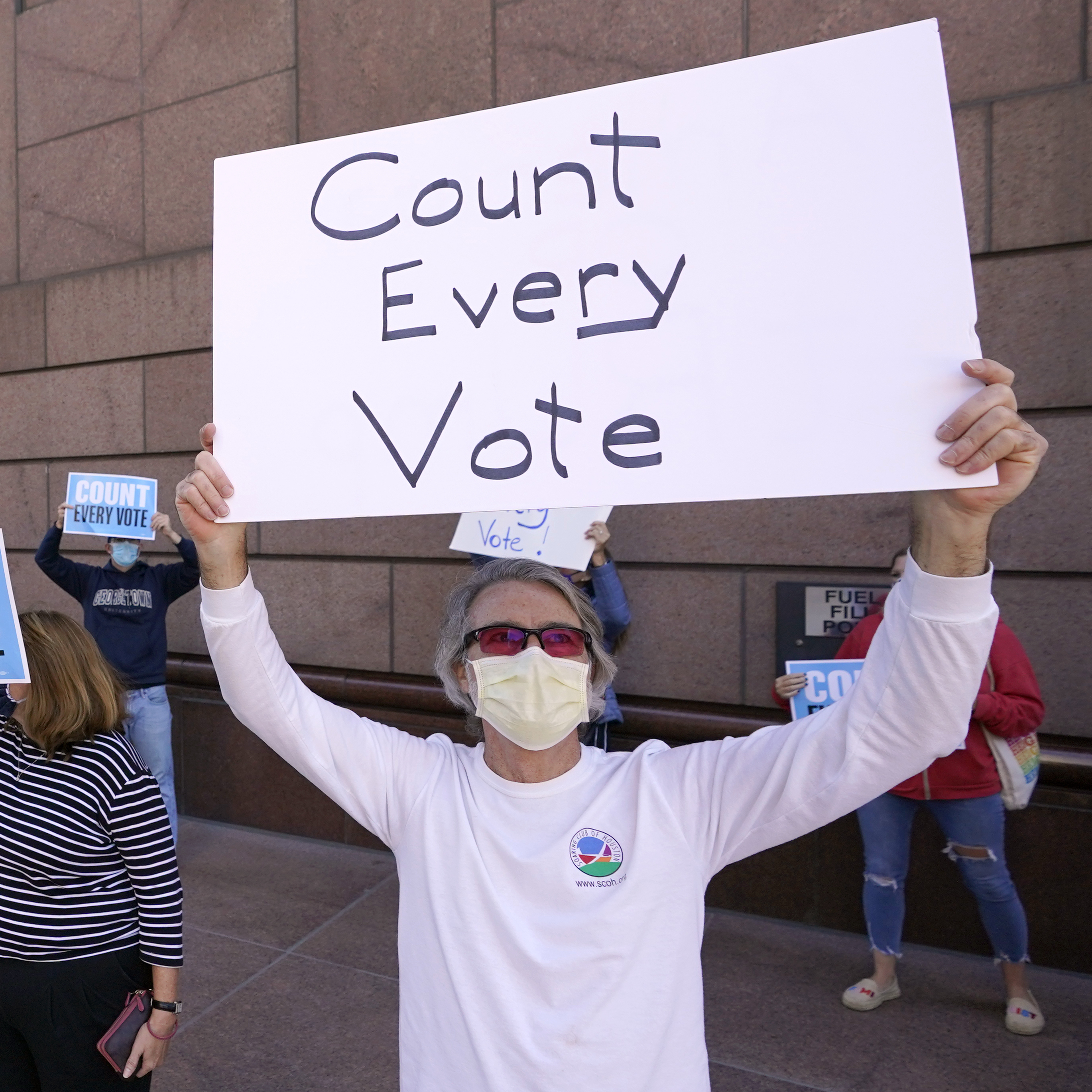 caption: Demonstrators stand across the street from the federal courthouse in Houston, Monday, Nov. 2, 2020, before a hearing in federal court involving drive-thru ballots cast in Harris County.