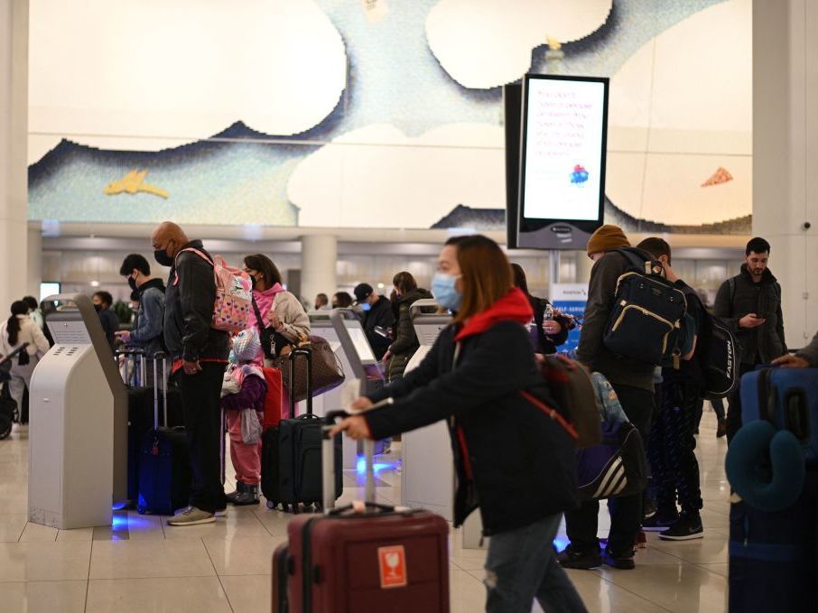 caption: Travelers wear masks at LaGuardia International Airport on Tuesday in New York, New York as concern grows worldwide over omicron, the newest COVID-19 variant. Minnesota confirmed the second U.S. omicron case on Thursday.