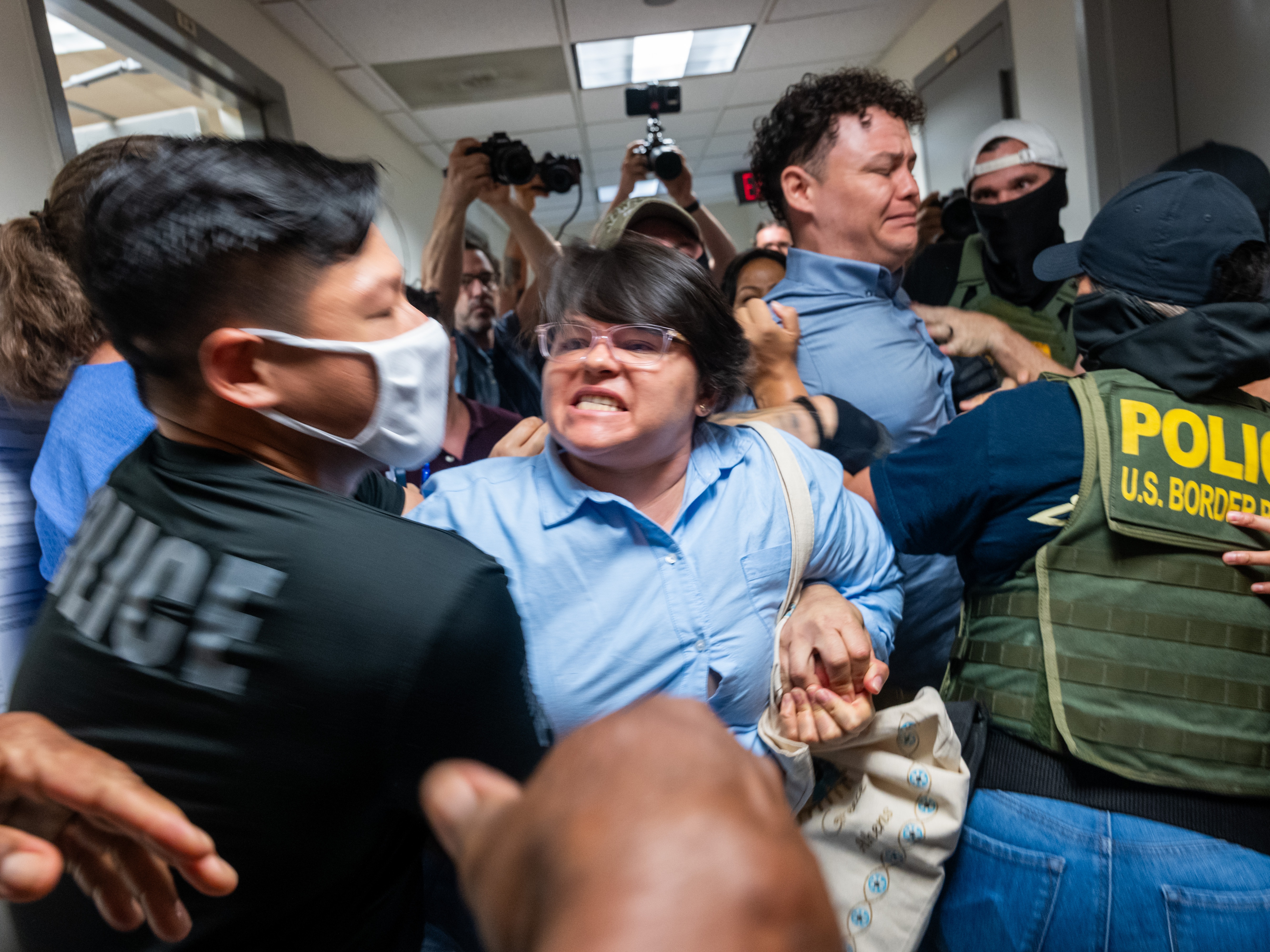caption: A Paraguayan woman whose relative was detained by federal agents scuffles with officers in the halls of immigration court at the Jacob K. Javitz Federal Building on in New York City in July 2025.