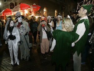 caption: Goblins mix with elves in less scary times, celebrating Halloween in Salem, Mass., in 2007.