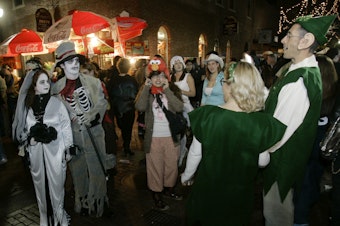 caption: Goblins mix with elves in less scary times, celebrating Halloween in Salem, Mass., in 2007.