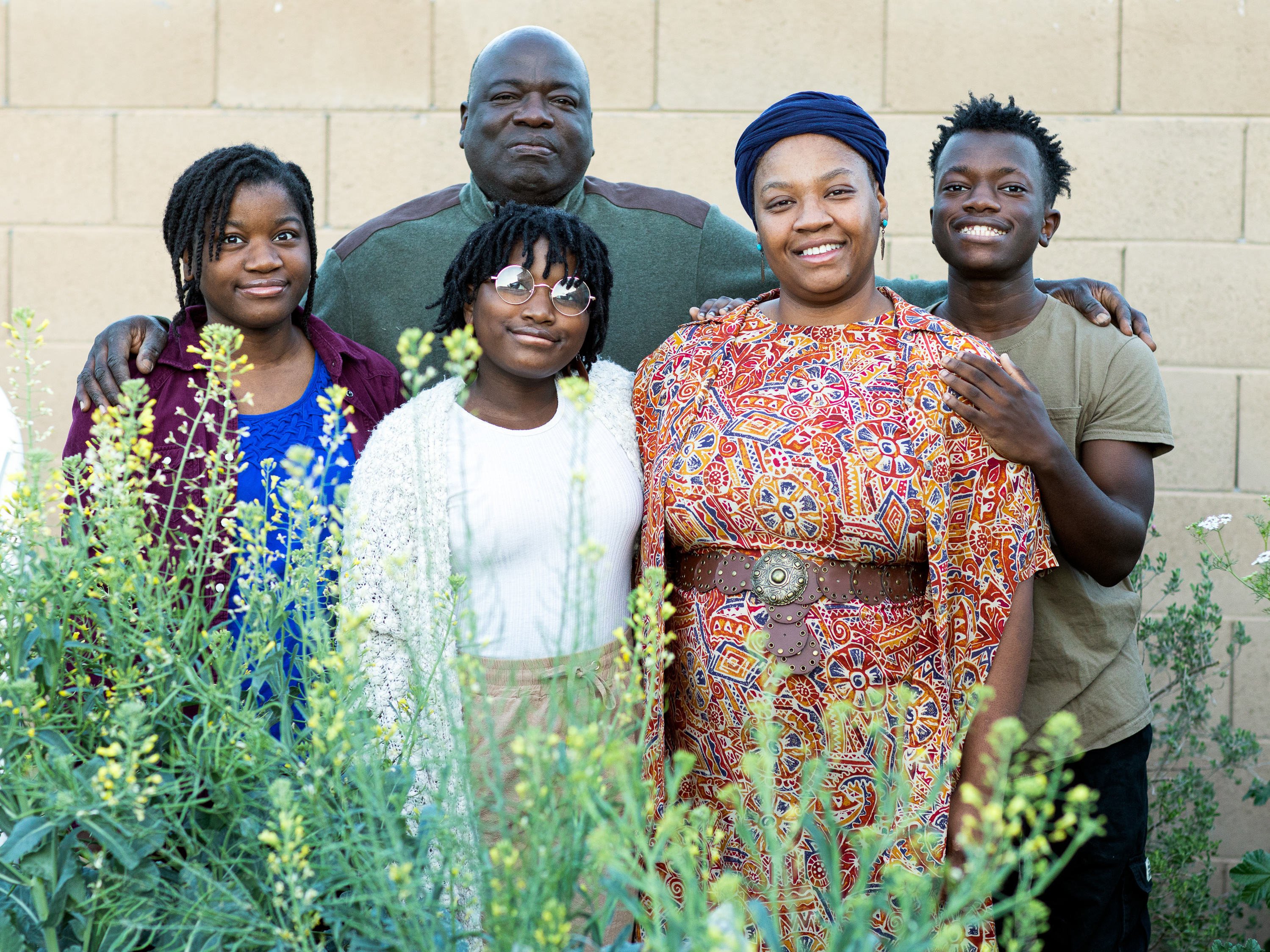 caption: Lakisa Muhammad with her husband, Dewayne, and children Yasina, 17, Hassana, 13, and Amir, 17, in their garden at home in Maricopa, Ariz.
