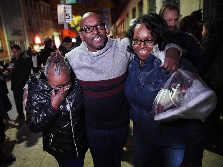 caption: Andrew Stewart (center) walks with his mother and sister on Monday after he and two other black men were exonerated in a 1983 murder for which they were sentenced to life in prison.
