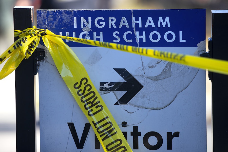 caption: Police tape connects to a visitor parking sign following a school shooting on Tuesday, November 8, 2022, at Ingraham high school in Seattle. 