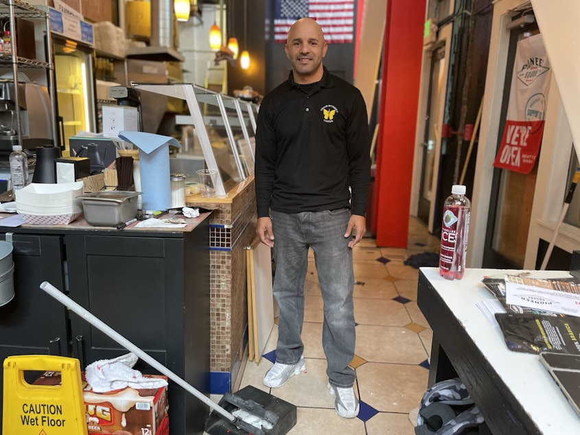 caption: Robert Rodriguez is working behind boarded up windows to open Yellow Butterfly Coffee in Pioneer Square / Downtown Seattle