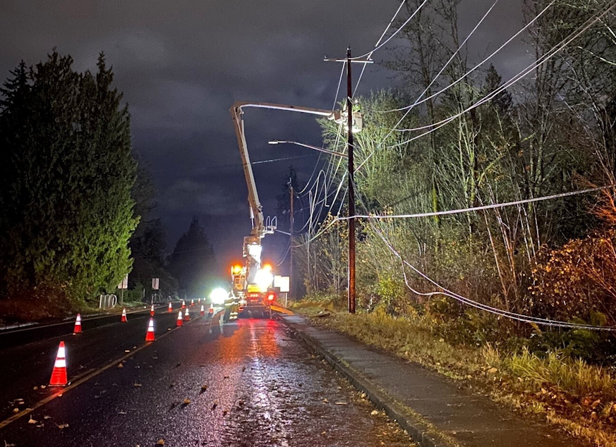 caption: Crews with Snohomish County PUD repair a damaged powerline after a powerful storm with rain and high winds swept through Western Washington Friday.