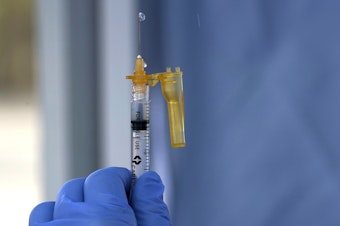 caption: FILE - In this March 4, 2021, file photo a syringe of the Moderna COVID-19 vaccine is shown at a drive-up mass vaccination site in Puyallup, Wash., south of Seattle.