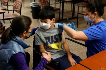 caption: Ari Blank got a comforting hand squeeze from his mom in May as he was vaccinated against COVID-19 in Bloomfield Hills, Mich. This week the U.S. Food and Drug Administration authorized the use of Pfizer's vaccine in even younger kids — ages 5-11.