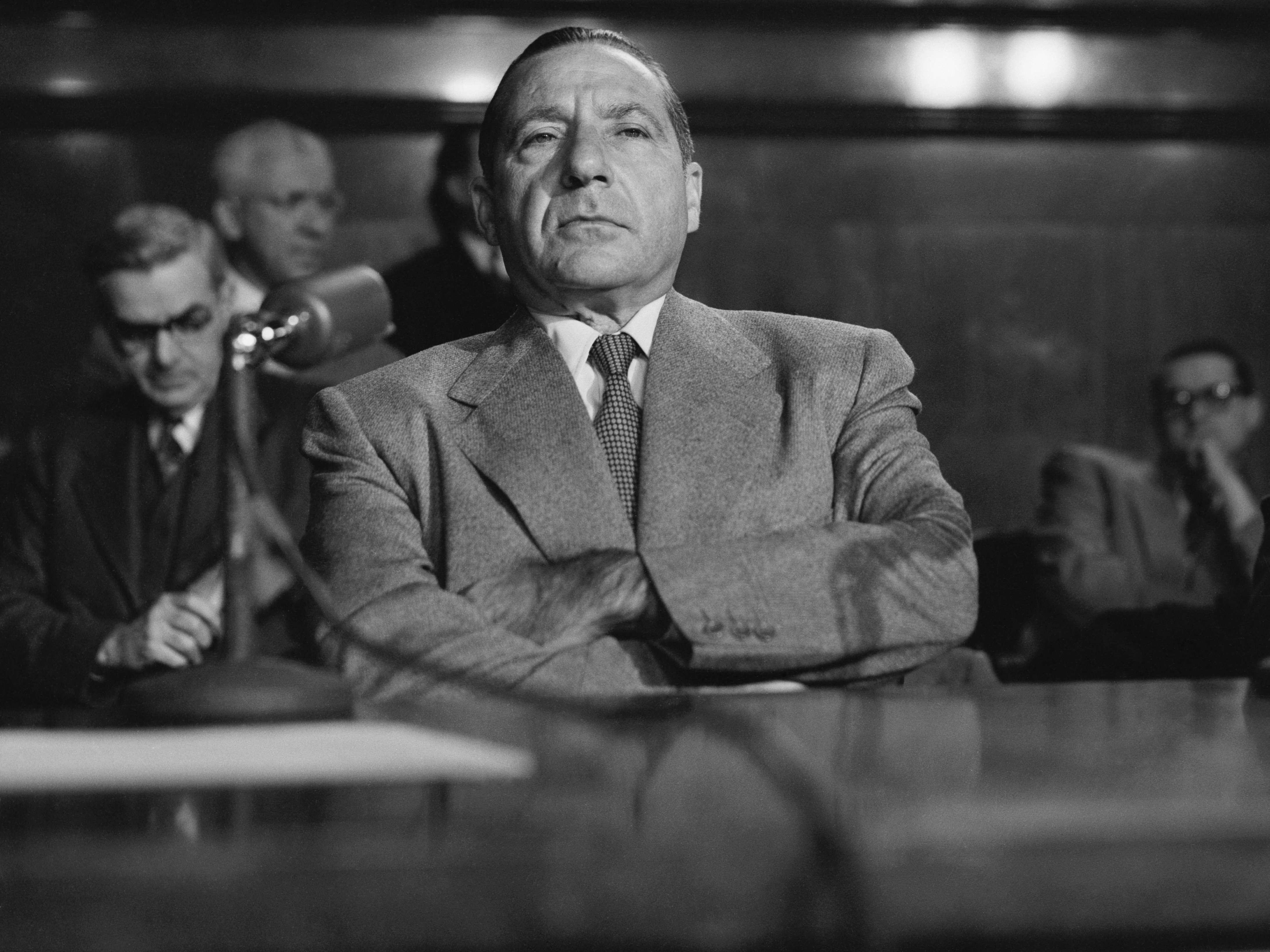 caption: Frank Costello, the powerful New York crime figure, sits patiently during testimony before the Kefauver Senate investigating committee in 1951.