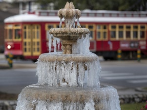 caption: The fountain is frozen as temperatures hovered in the mid 20s at Jacob Schoen & Son Funeral Home in New Orleans on Dec. 24, 2022.