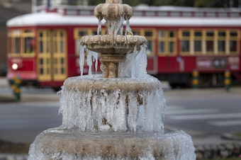 caption: The fountain is frozen as temperatures hovered in the mid 20s at Jacob Schoen & Son Funeral Home in New Orleans on Dec. 24, 2022.