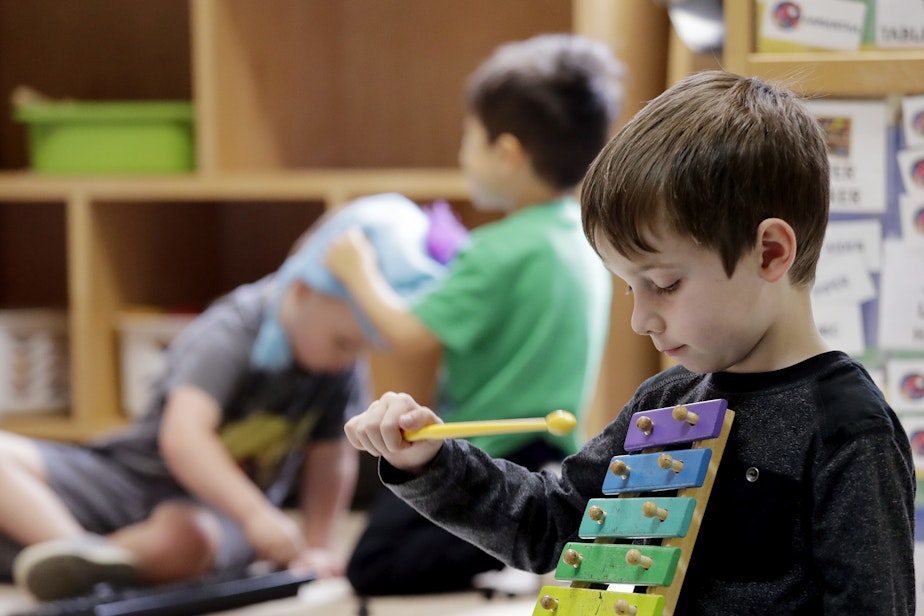 caption: Elliott O'Neil plays on a xylophone at the Wallingford Child Care Center in Seattle. (Elaine Thompson/AP)