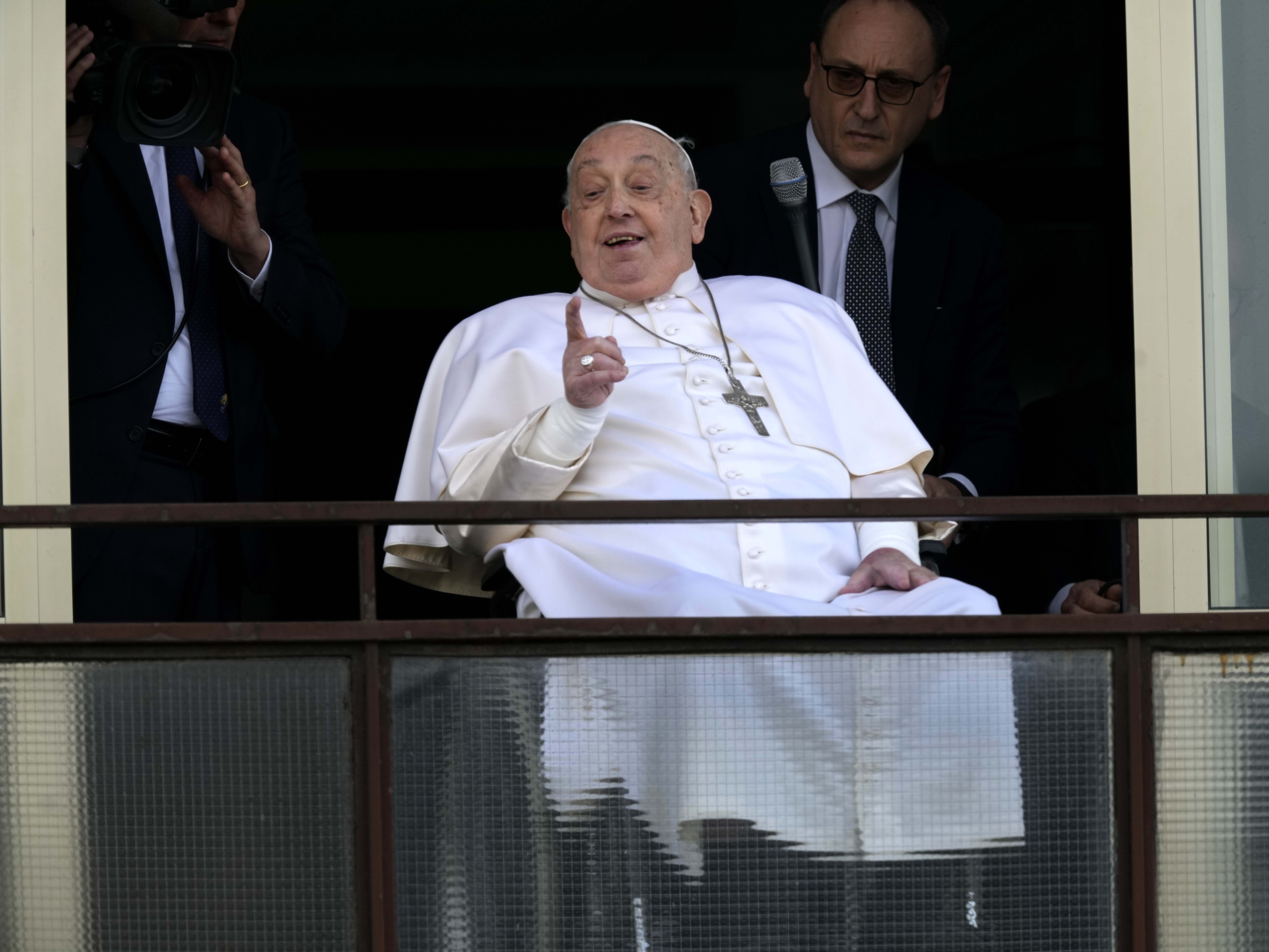 caption: Pope Francis gestures as he appears at a window of the Agostino Gemelli Polyclinic in Rome on Sunday.
