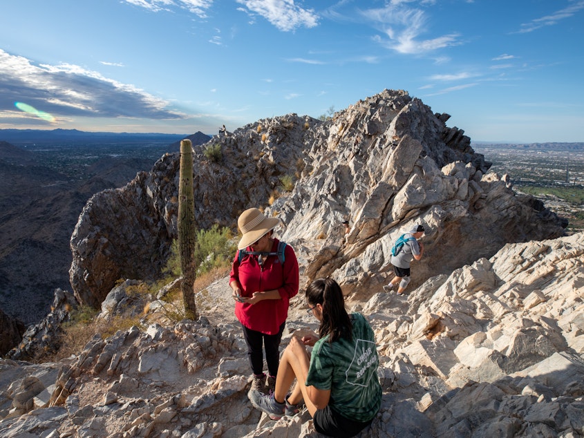 caption: Early morning hikers rest before walking down Piestewa Peak, a city park in Phoenix, Ariz. El Niño drives even hotter, drier weather in the Southwest United States, on top of growing heat risk from human-caused climate change.