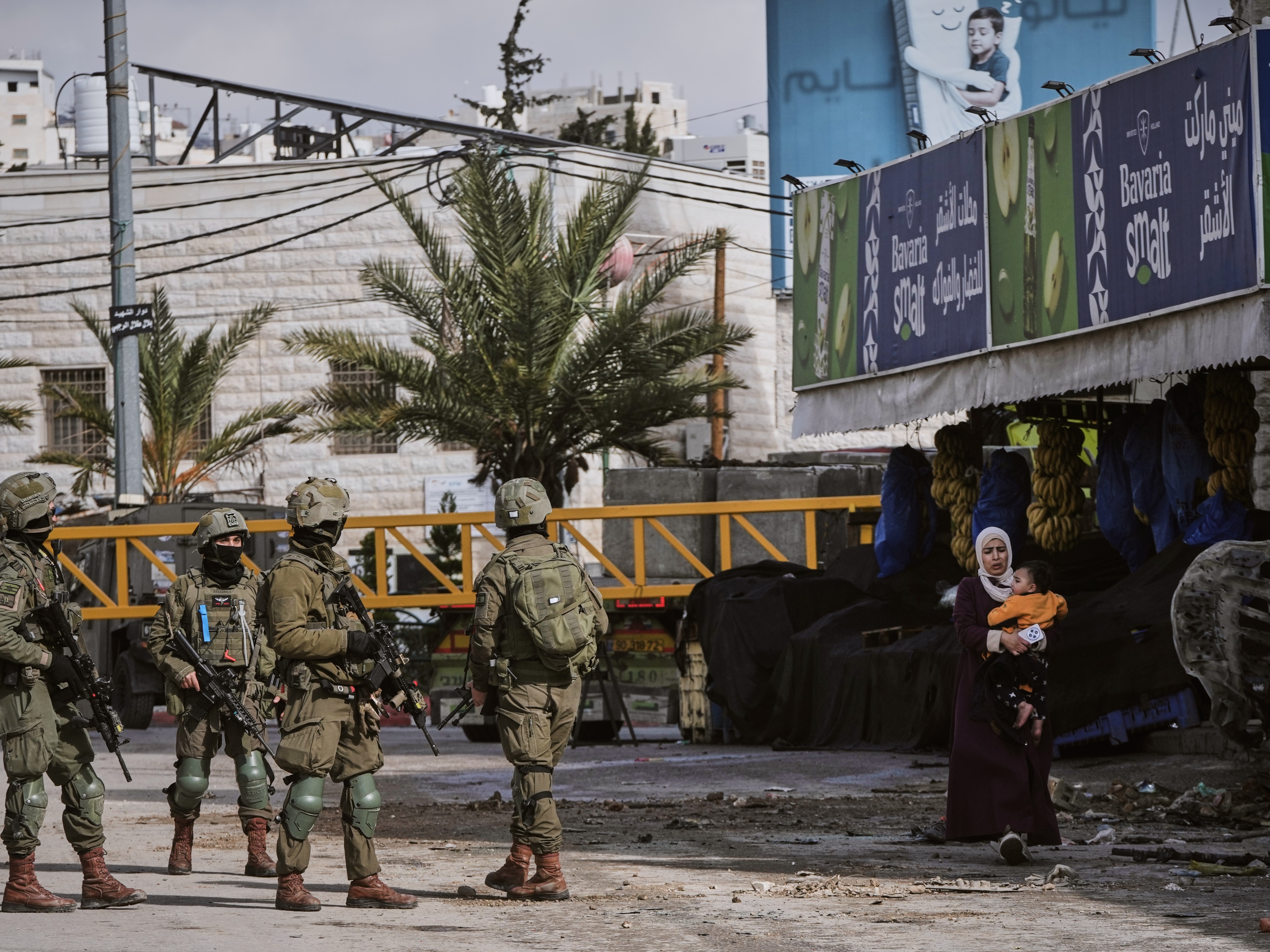 caption: Israeli soldiers take up positions during an army raid in the West Bank city of Hebron Monday, Jan. 19, 2026.