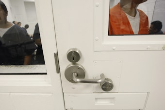 caption: Detainees are shown inside a holding cell at the Northwest Detention Center in Tacoma, Wash., Friday, Oct. 17, 2008. 