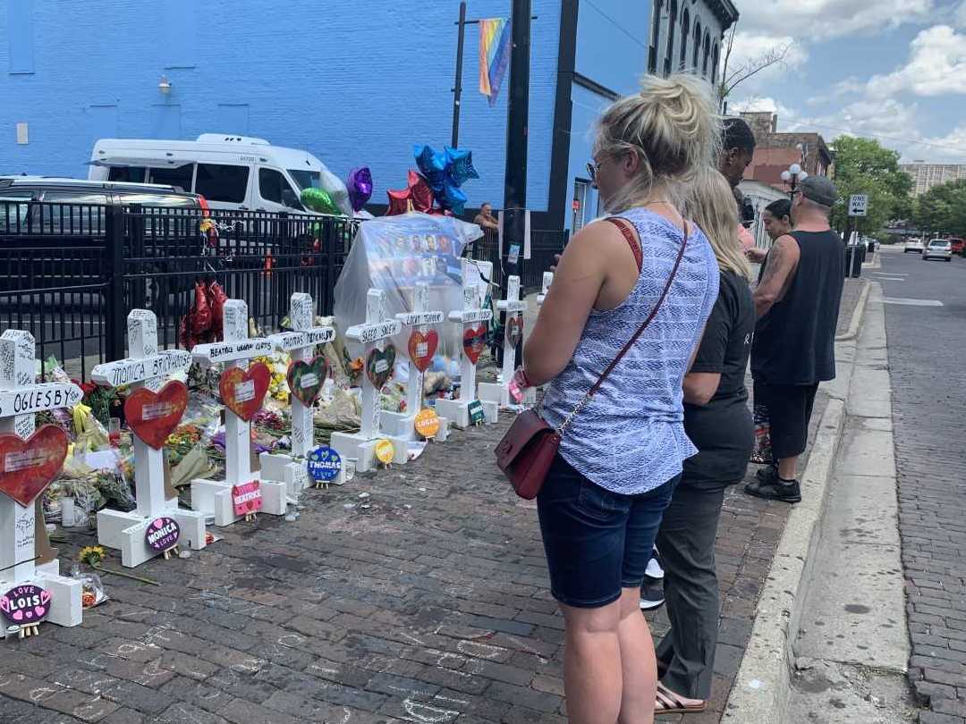 caption: Onlookers in Dayton mourn the nine people who died when a gunman opened fire in a crowd outside a popular bar in the city's Oregon District earlier this month.