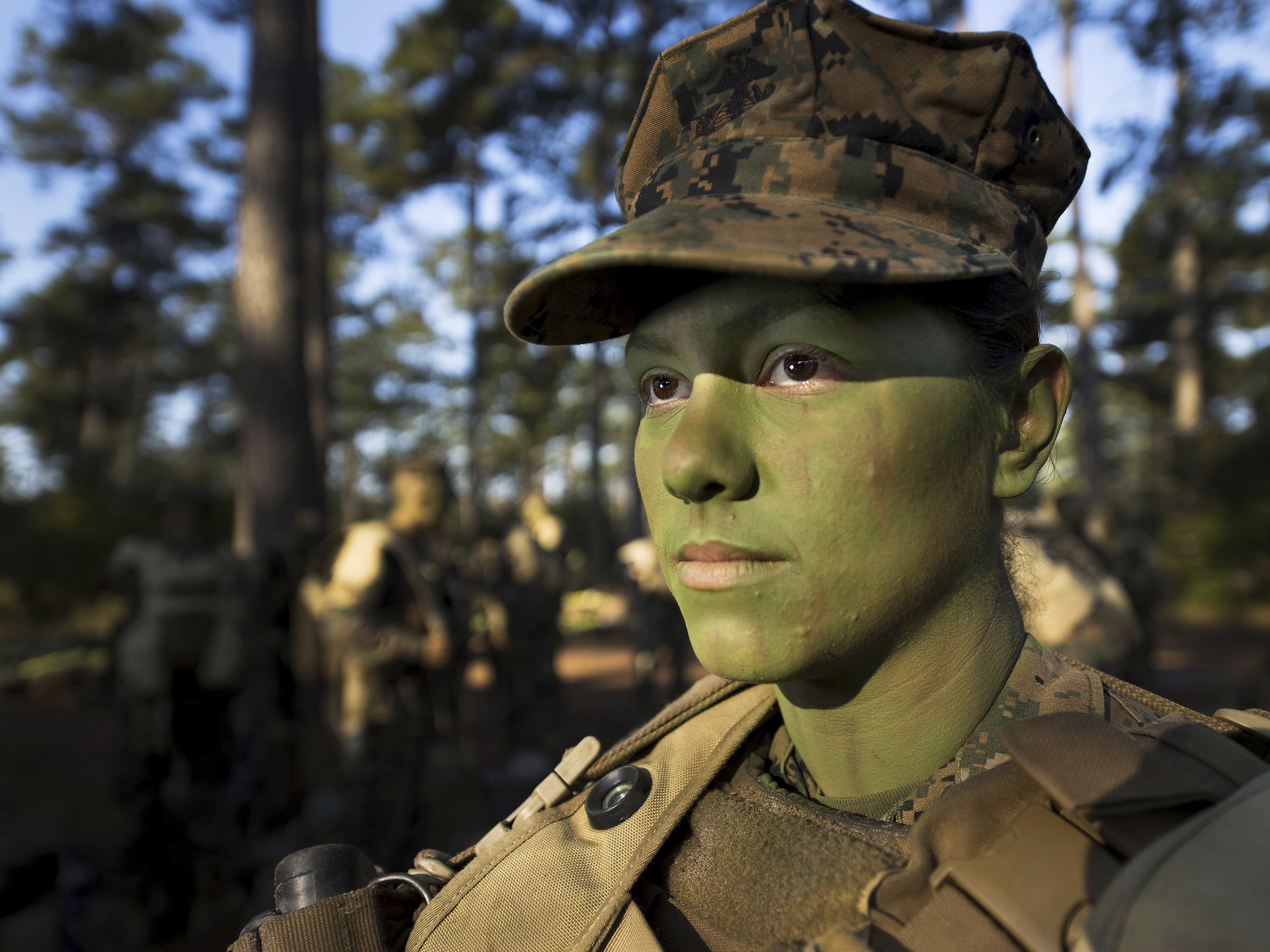caption: Pfc. Christina Fuentes Montenegro prepares to hike to her platoon's defensive position during patrol week of Infantry Training Battalion near Camp Geiger, N.C., in 2013.