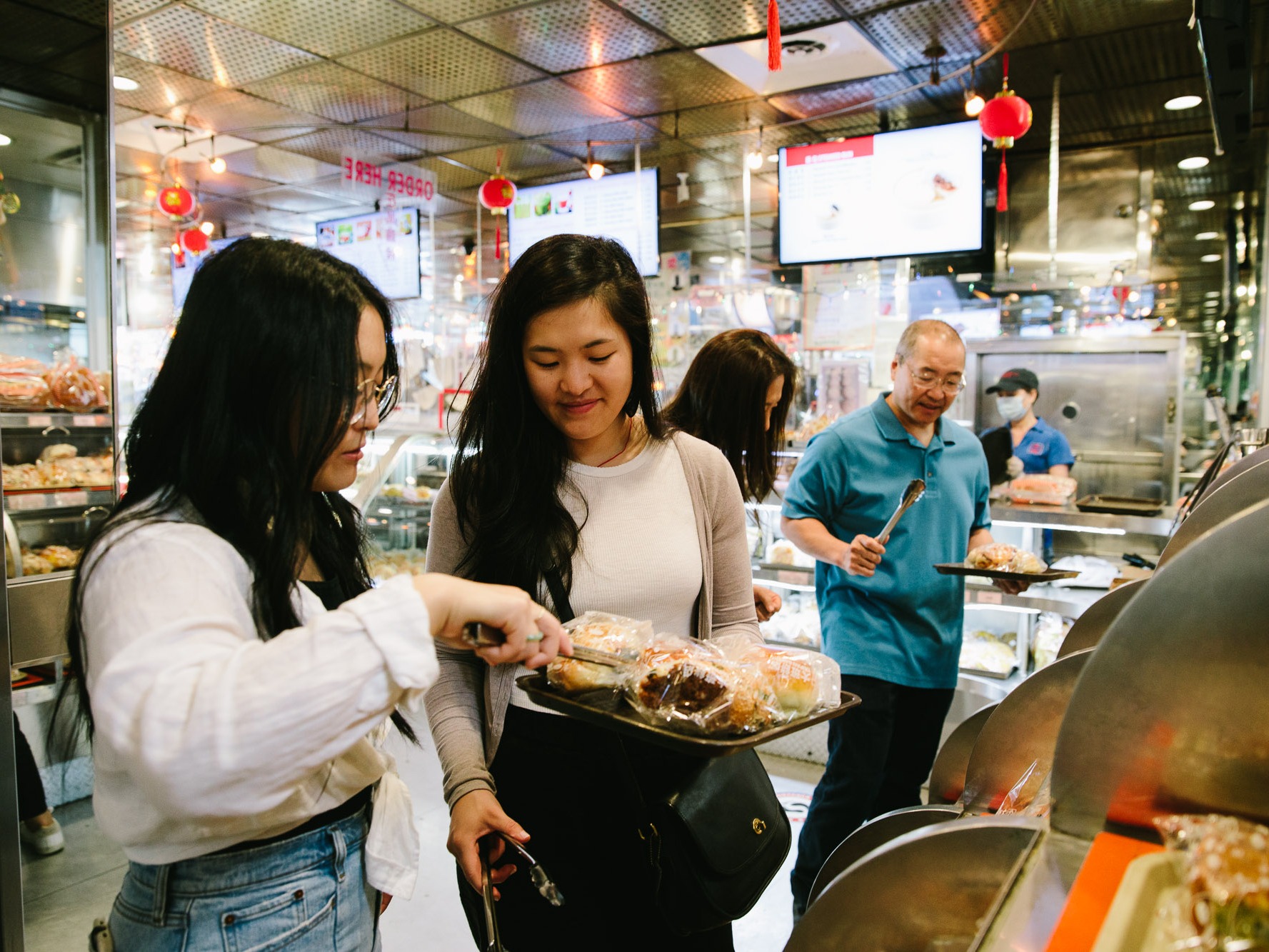 caption:  Sarah and Kaitlin Leung develop recipes with their parents for their blog, <em>The Woks of Life</em>. 
