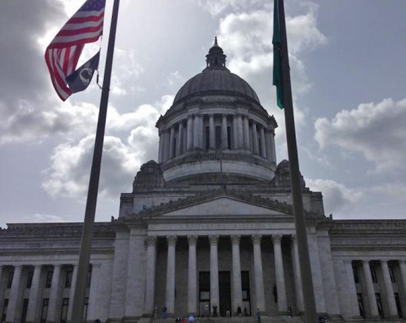 caption: Flags fly at half mast in front of Washington State Capitol.