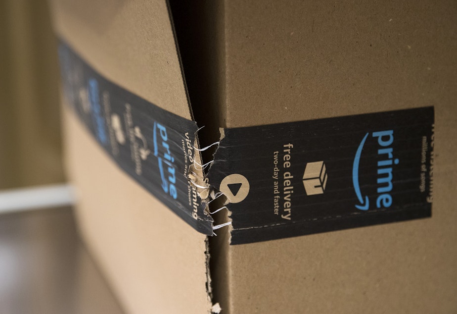 caption: An Amazon package is tested with a vertical compression tester on Tuesday, October 22, 2019, at an Amazon Packaging Lab in Seattle. 
