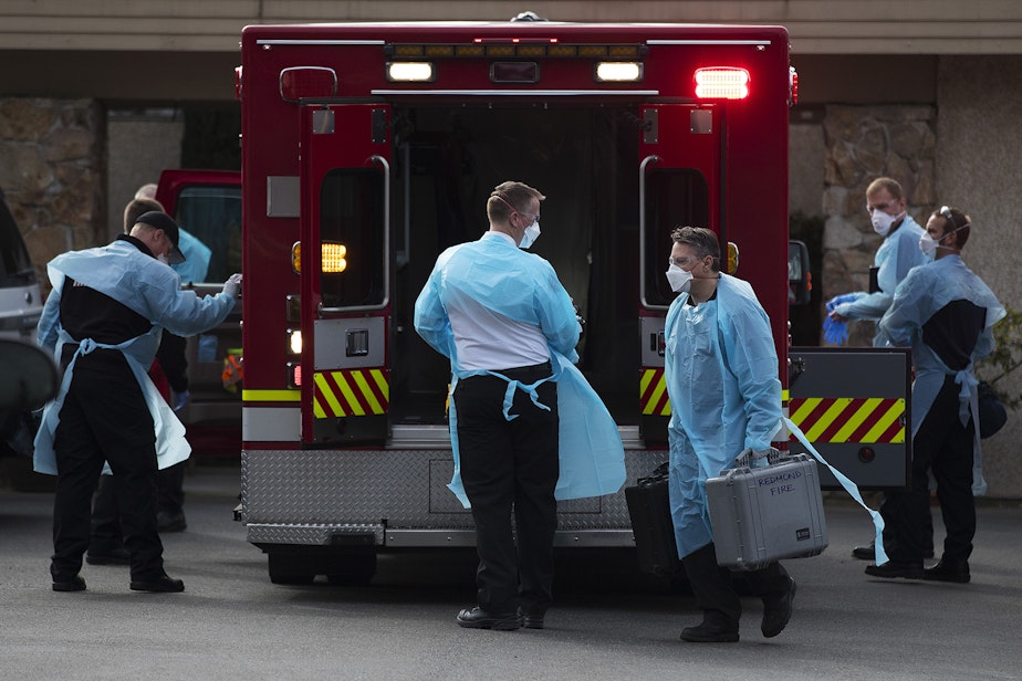 caption: First responders and members of the Kirkland Fire Department arrive at the Life Care Center of Kirkland to transport a resident to the hospital on Thursday, March 5, 2020, in Kirkland.