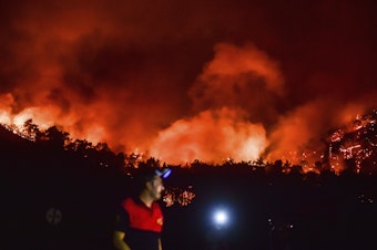 caption: A man leaves as advancing fires rage the Hisaronu area, Turkey on Monday. For the sixth straight day, Turkish firefighters battled the blazes that are tearing through forests near Turkey's beach destinations.