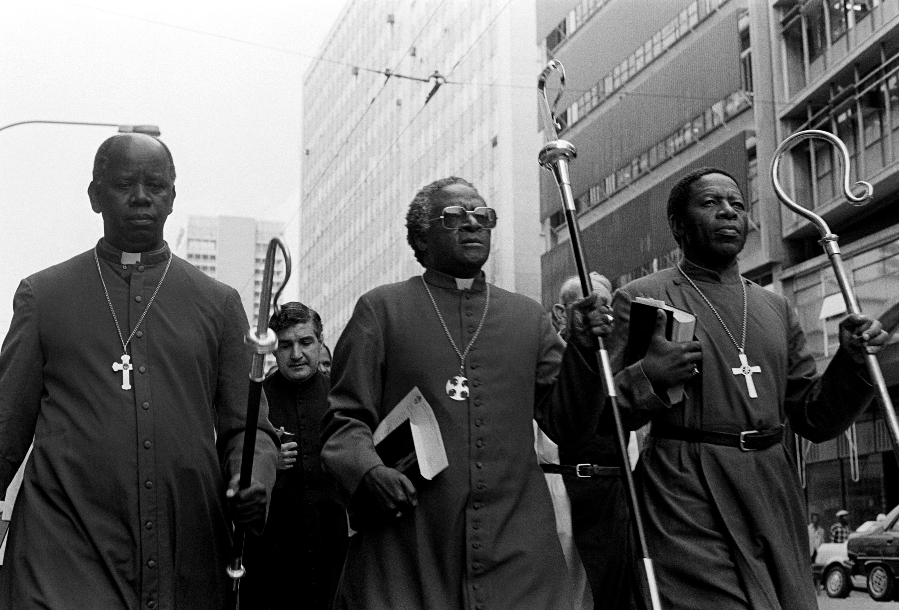 caption: South African activist and Anglican Archbishop Desmond Tutu (center) leads some 30 clergymen through Johannesburg to police headquarters in 1985 to hand in a petition calling for the release of political detainees.