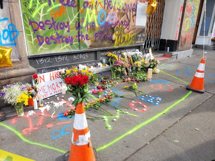 caption: A memorial vigil where A 19-year-old man was killed early Saturday morning, June 20, 2020. In the background is the Rancho Bravo medic station where CHOP medics performed CPR before he was taken to Harborview.