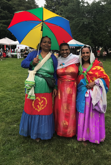 caption: Akberet Asfaha (left) poses with friends at an event to celebrate Eritrea's Day of Independence.