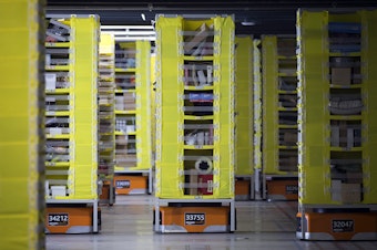 caption: Robotic drive units transfer items at an Amazon fulfillment center on Friday, November 3, 2017, in Kent. 