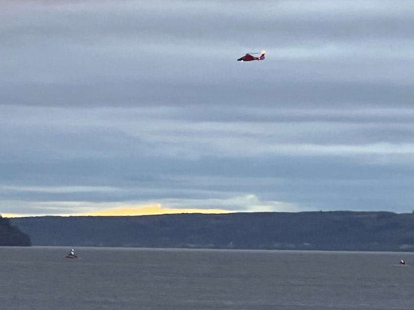 caption: A Coast Guard helicopter searches the area where a floatplane crashed near Whidbey Island, Wash., Sunday, Sept. 4, 2022.