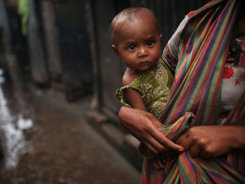 caption: A women holds a child in the alley of a slum in Dhaka, Bangladesh. Bangladesh is one of the world's poorest countries; nearly 40% of the population survive on less than a dollar a day.