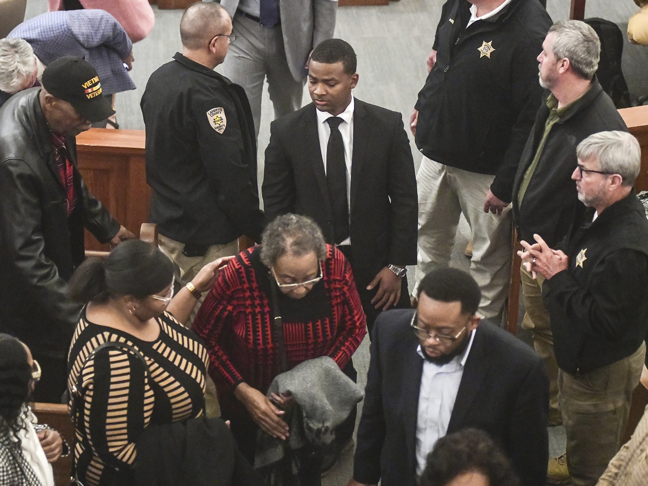 caption: Sheldon "Timothy" Herrington Jr., center, who was on trial for the murder of University of Mississippi student Jimmie "Jay" Lee, joins family as they leave court after a mistrial was declared, at the Lafayette County Courthouse in Oxford, Miss. on Wednesday.