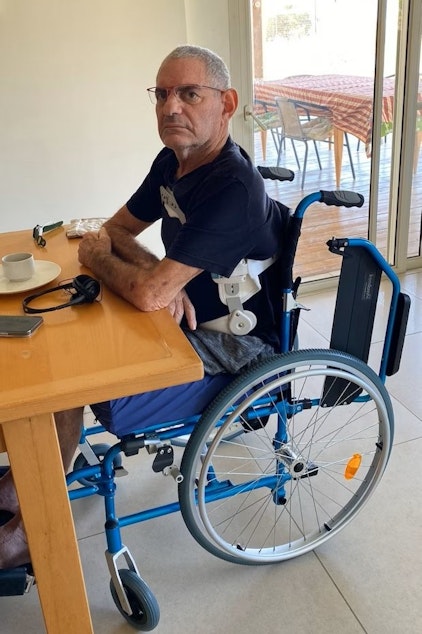 caption: Natalie Smith's uncle, Eviatar Kipnis, 65, sits at his kitchen table in Israel.